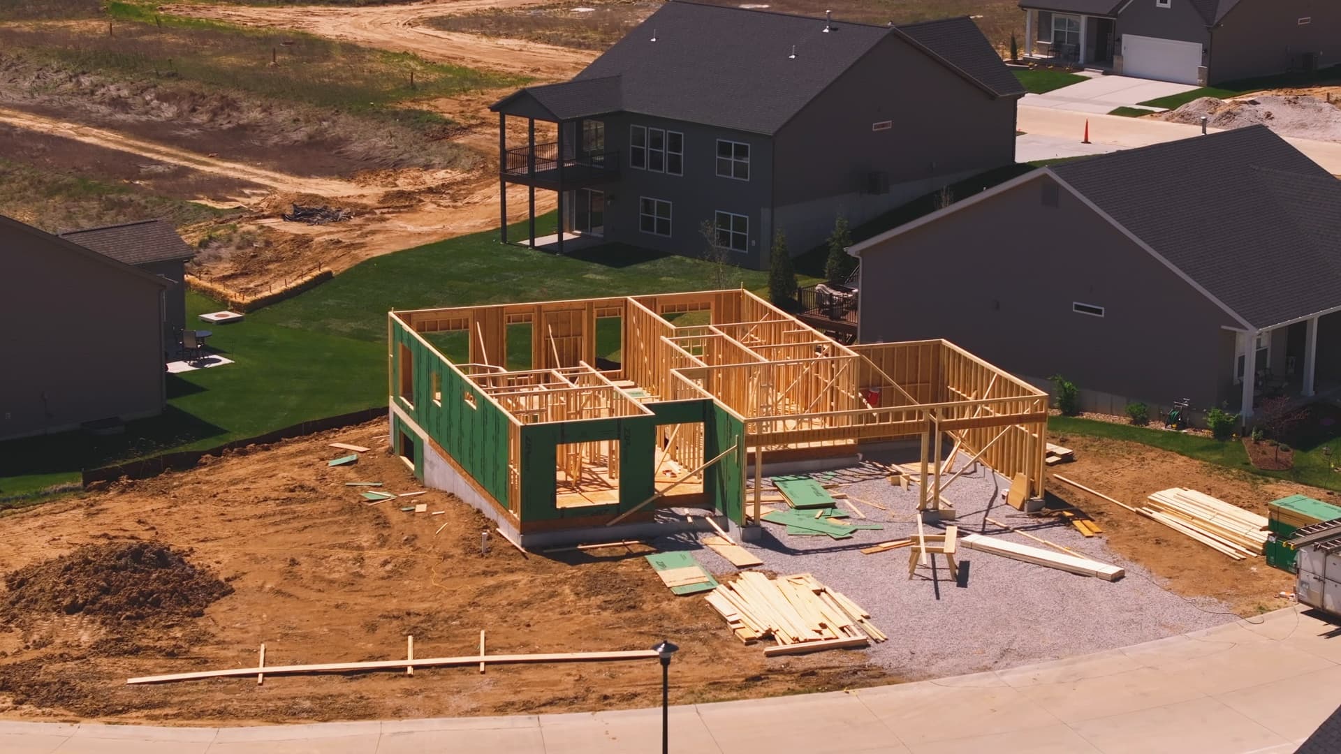 A residential subdivision from above, one house being framed
