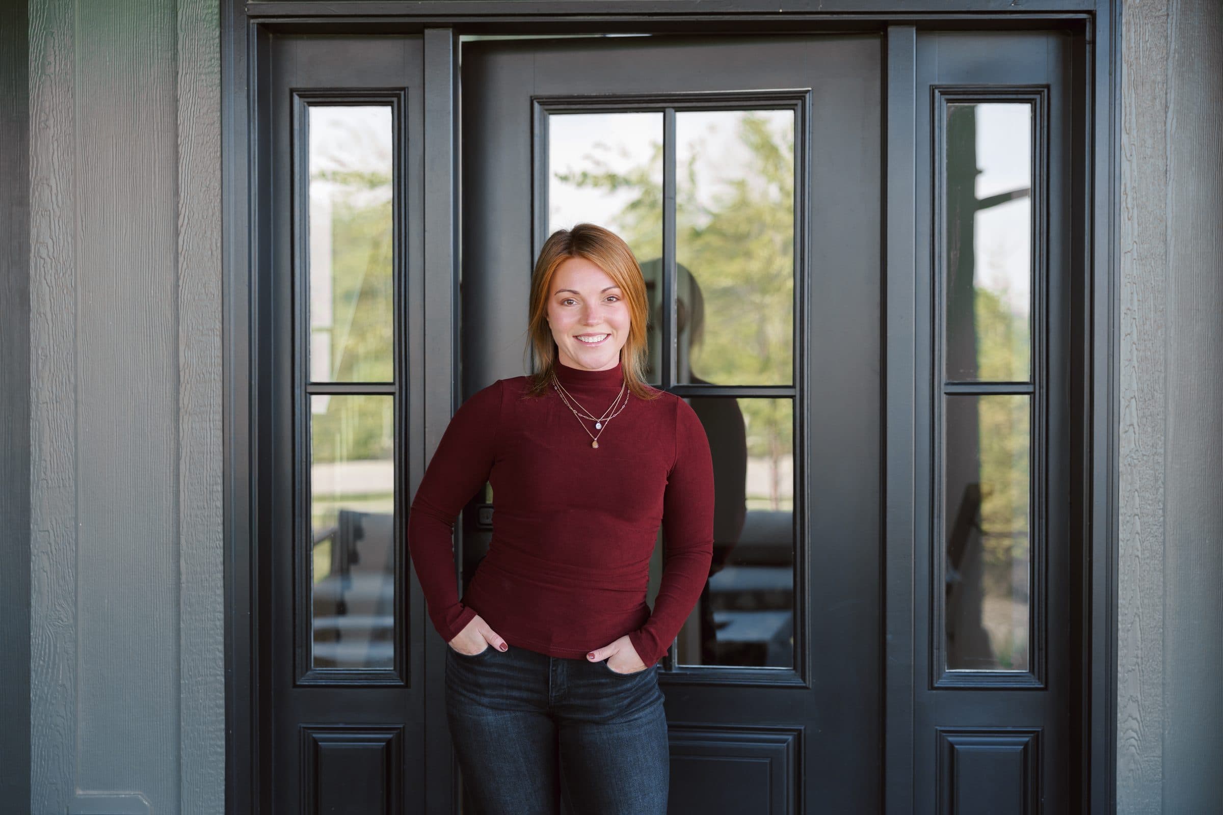 Jenna Gray, Dayton realtor, at the black front door of a home in the Dayton area