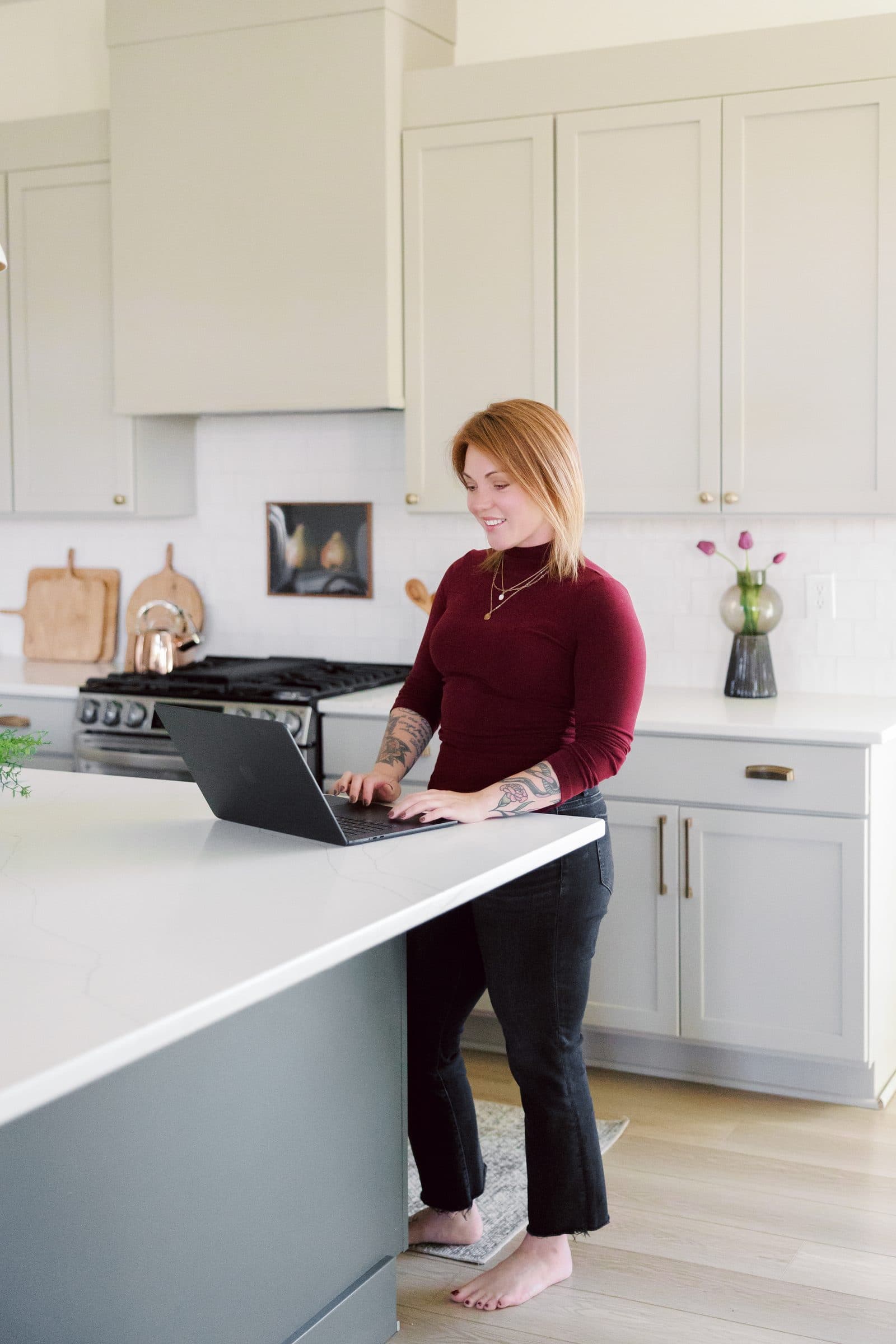 Jenna Gray, Dayton realtor, at a laptop at a kitchen island