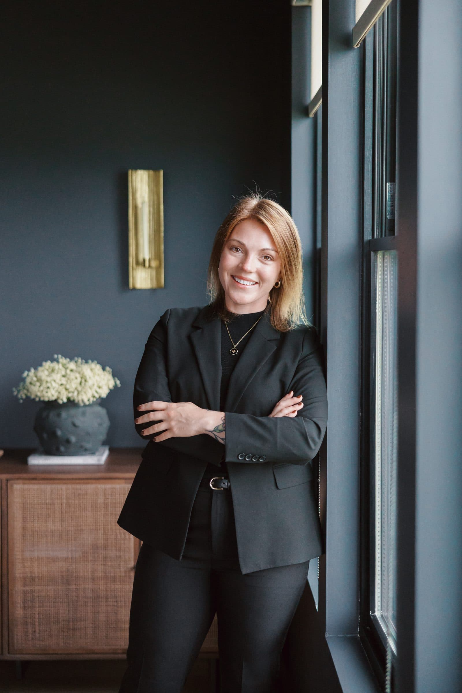 Jenna Gray, REALTOR® with Plum Tree Realty, Dayton, Ohio, standing at a tall window