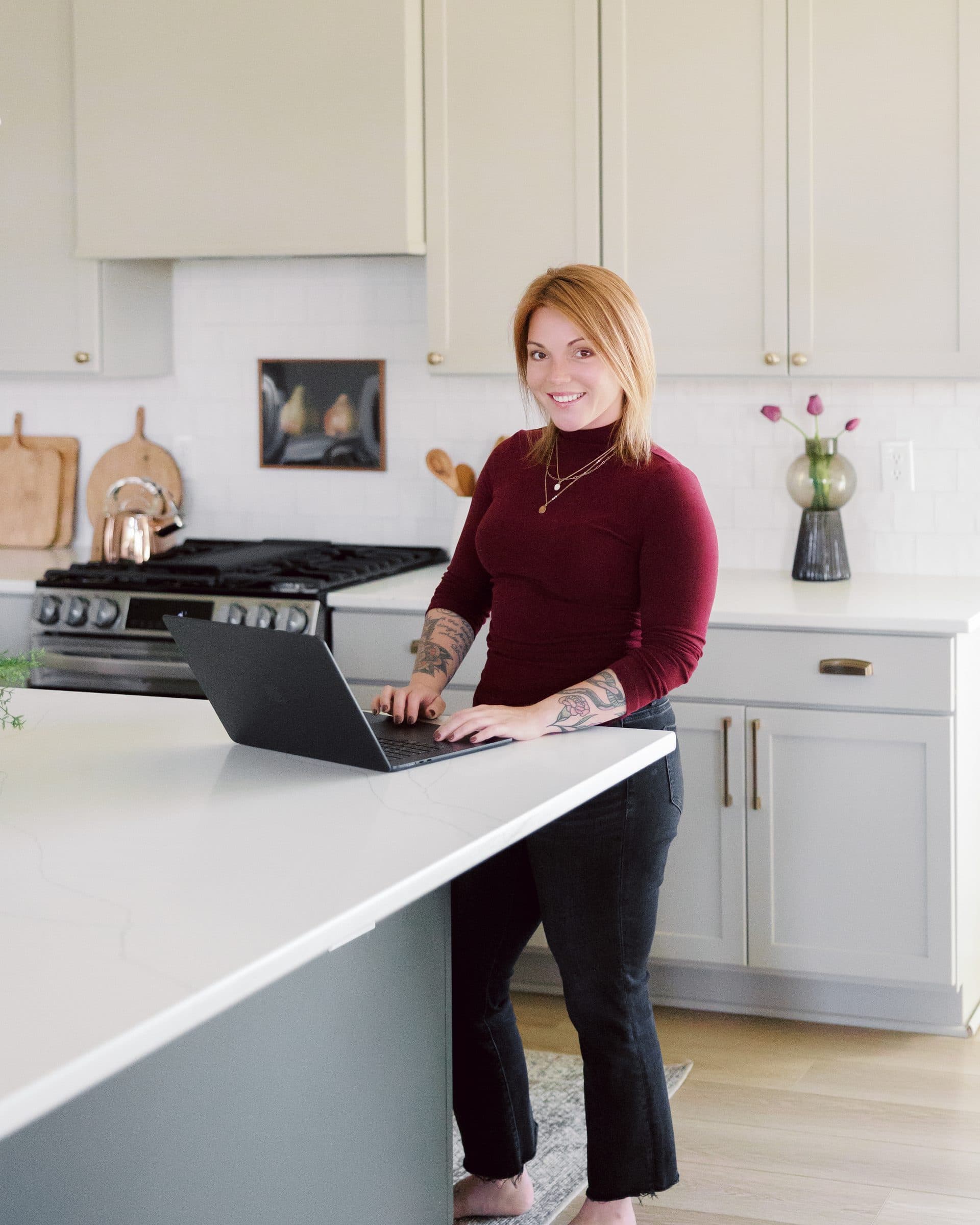 Jenna Gray, Dayton realtor, at a kitchen island with her laptop